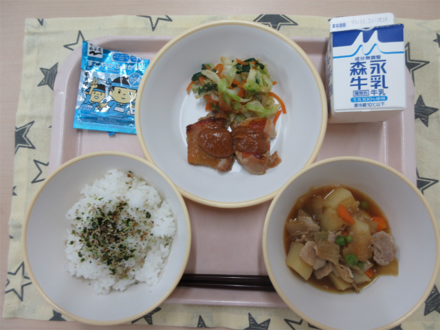 ピンクのトレーに給食が右上から反時計回りで牛乳、ごま和え、鶏肉の味噌焼き、わかめふりかけのかかったごはん、肉じゃがと並べられている写