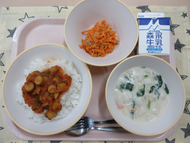 ピンクのトレーに給食が右上から反時計回りで牛乳、ツナとにんじんのソテー、ジャンバラヤ（ごはん）、かぶのミルクスープと並べられている写真