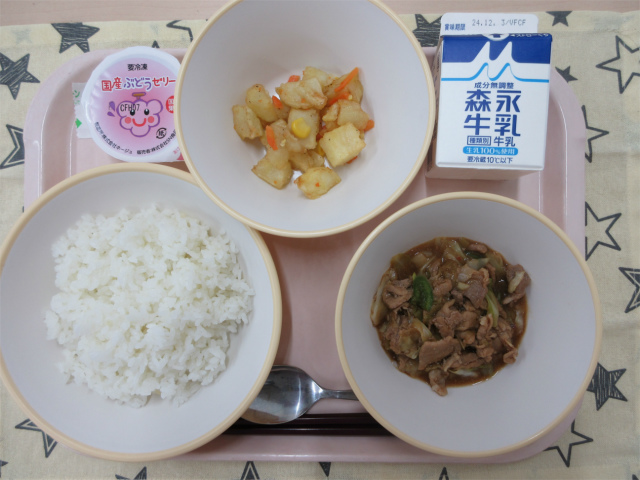 ピンクのトレーに給食が右上から反時計回りで牛乳、じゃがいものソテー、ぶどうゼリー、ごはん、ホイコーロー丼の具と並べられている写真