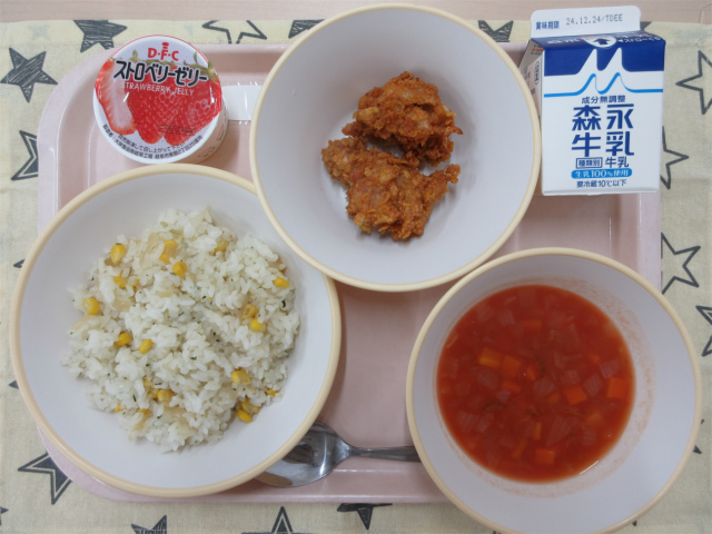 ピンクのトレーに給食が右上から反時計回りで牛乳、クリスピーチキン 、いちごゼリー、コーンピラフ、ミネストローネと並べられている写真