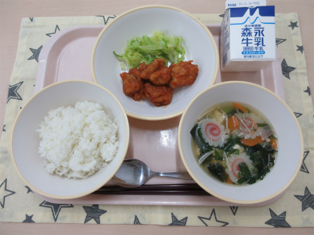 ピンクのトレーに給食が右上から反時計回りで牛乳、ゆでキャベツ 、ヤンニョムチキン、ごはん、わかめスープと並べられている写真