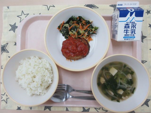 ピンクのトレーに給食が右上から反時計回りで牛乳、海藻サラダ、ハンバーグトマトソース、ごはん、ビーフンスープと並んでいる写真