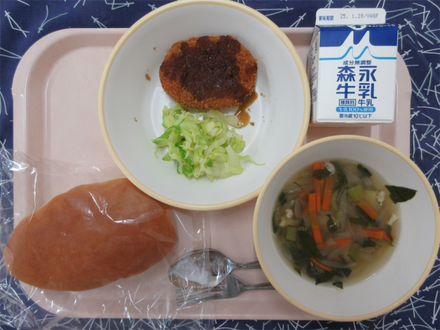 ピンクのトレーに給食が右上から反時計回りで牛乳、コロッケとせん切りキャベル、サンドパン、コンソメスープと並べられている写真