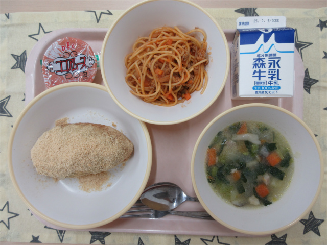 ピンクのトレーに給食が右上から反時計回りで牛乳、スパゲティミートソース、ココアムース、きな粉揚げパン、チキンポトフと並べられている写真