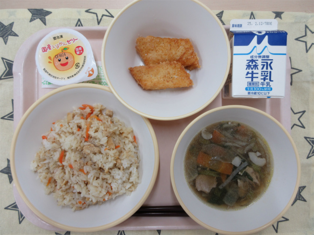 ピンクのトレーに給食が右上から反時計回りで牛乳、いかの吉野揚げ、いよかんゼリー、子ぎつね寿司、根菜汁と並べられている写真