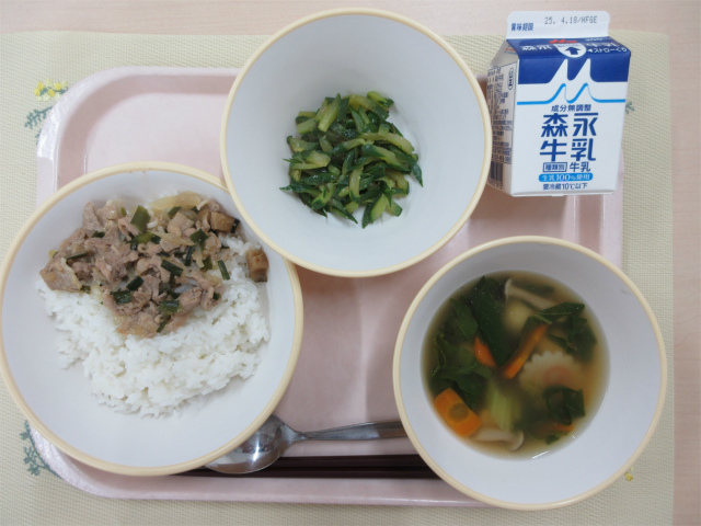 ピンクのトレーに給食が右上から反時計回りで牛乳、ピリ辛きゅうり、焼肉丼、白玉スープと並べられている写真