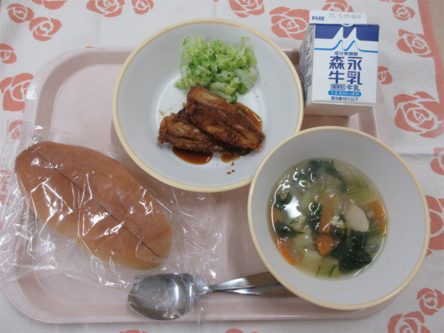 ピンクのトレーに給食が右上から反時計回りで牛乳、あじフライとゆでキャベツ、ソフトフランスパン、野菜のスープ煮と並べられている写真