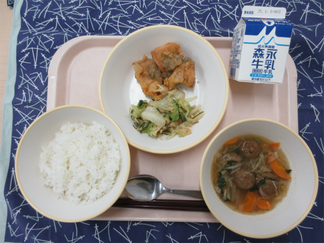 ピンクのトレーに給食が右上から反時計回りで牛乳、鶏肉の梅みそだれとささみとキャベツの昆布和え、ごはん、肉だんごと切干大根のピリ辛スープと並べられている写真