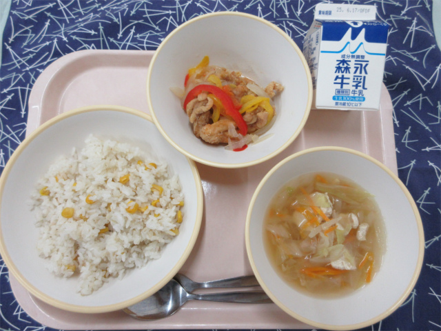 ピンクのトレーに給食が右上から反時計回りで牛乳、鶏肉のマリネ、コーンピラフ、コンソメスープと並べられている写真