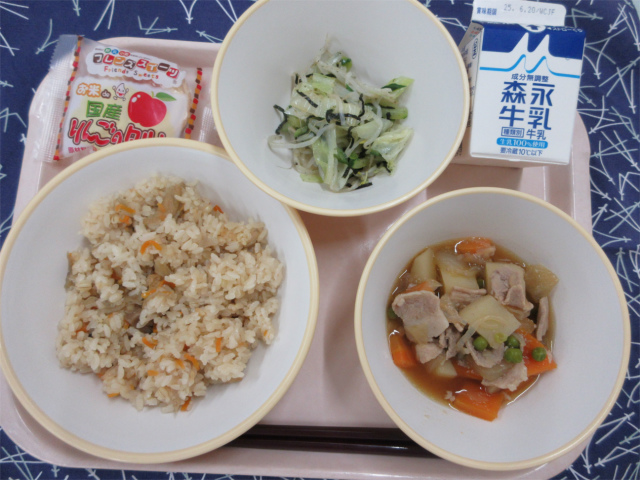 ピンクのトレーに給食が右上から反時計回りで牛乳、磯香和え、りんごタルト、かやくごはん、肉じゃがと並べられている写真