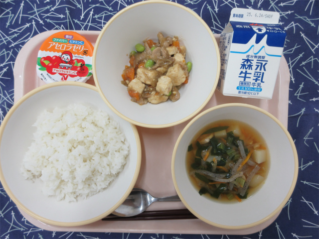 ピンクのトレーに給食が右上から反時計回りで牛乳、肉豆腐あんかけ丼の具、アセロラゼリー、ごはん、鶏けんちん汁と並べられている写真