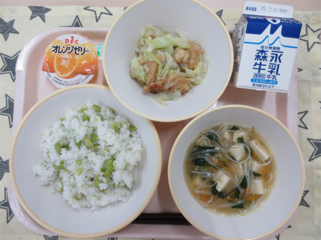 ピンクのトレーに給食が右上から反時計回りで牛乳、鶏肉とキャベツの旨塩炒め、オレンジゼリー、枝豆おこわ、ビーフンスープと並べられている写真