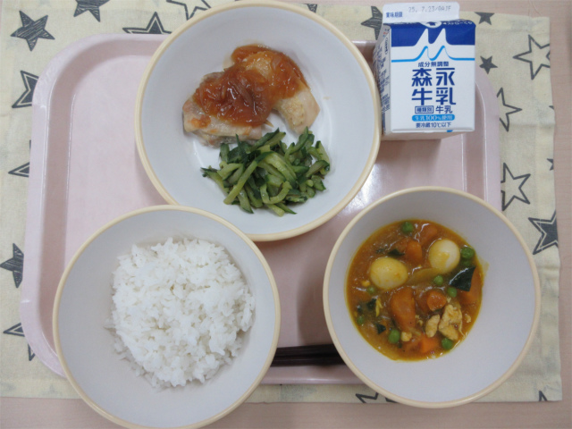 ピンクのトレーに給食が右上から反時計回りで牛乳、鶏肉の生姜焼きとピリ辛きゅうり、ごはん、かぼちゃの中華煮と並べられている写真