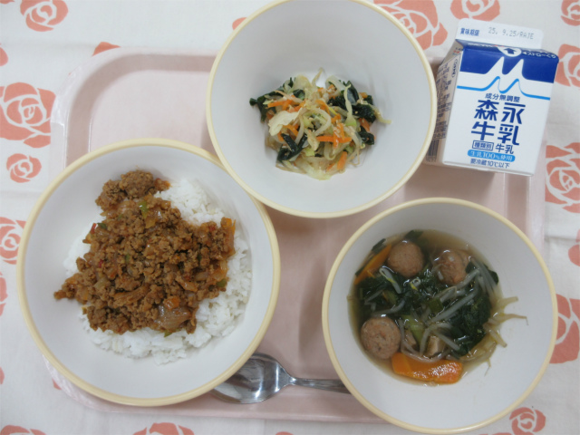 ピンクのトレーに給食が右上から反時計回りで牛乳、海藻サラダ 、トマトとひき肉のアジアンライス、五目中華スープと並べられている写真