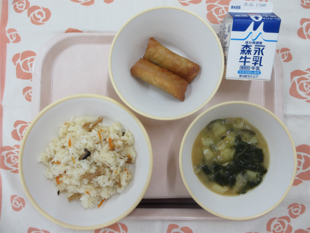 ピンクのトレーに給食が右上から反時計回りで牛乳、春巻き、ちらし寿司、じゃがいもの味噌汁と並べられている写真