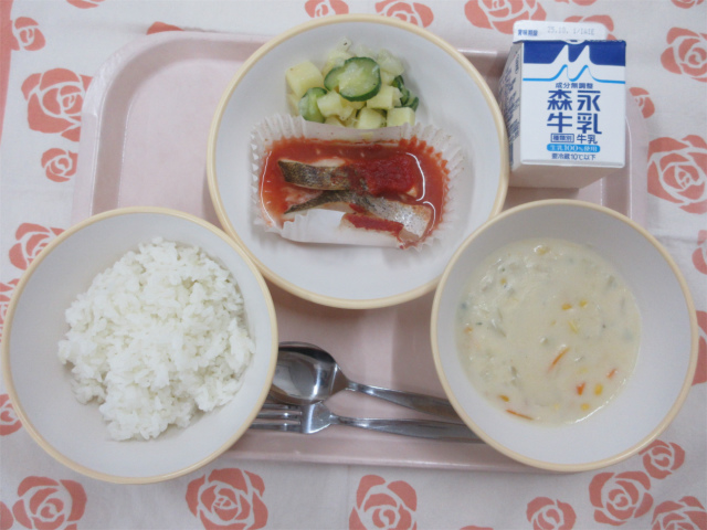 ピンクのトレーに給食が右上から反時計回りで牛乳、ポテトサラダ、白身魚のトマトソース、ごはん、コーンシチューと並べられている写真