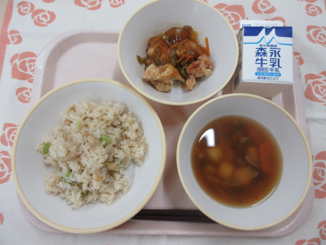 ピンクのトレーに給食が右上から反時計回りで牛乳、鶏肉と野菜のあんかけ、まめまめごはん、月見汁と並べられている写真