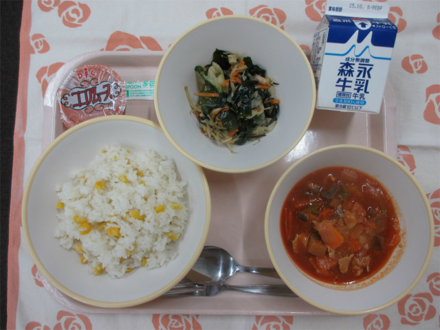 ピンクのトレーに給食が右上から反時計回りで牛乳、海藻サラダ、ココアムース、コーンピラフ、ラタトゥイユと並べられている写真