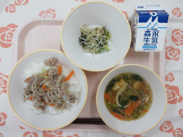 ピンクのトレーに給食が右上から反時計回りで牛乳、磯香和え、ねぎ塩豚丼、あんかけ汁と並べられている写真