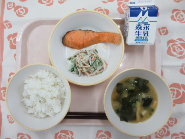 ピンクのトレーに給食が右上から反時計回りで牛乳、鮭の塩焼き、きゅうりのごまマヨ和え、ごはん、じゃがいもの味噌汁と並べられている写真