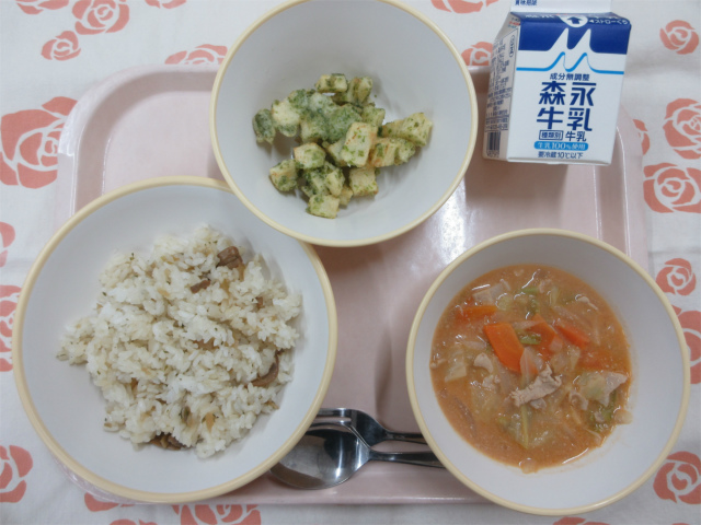 ピンクのトレーに給食が右上から反時計回りで牛乳、青のりポテト、ごぼうピラフ、豚肉とキャベツのトマトクリーム煮と並べられている写真