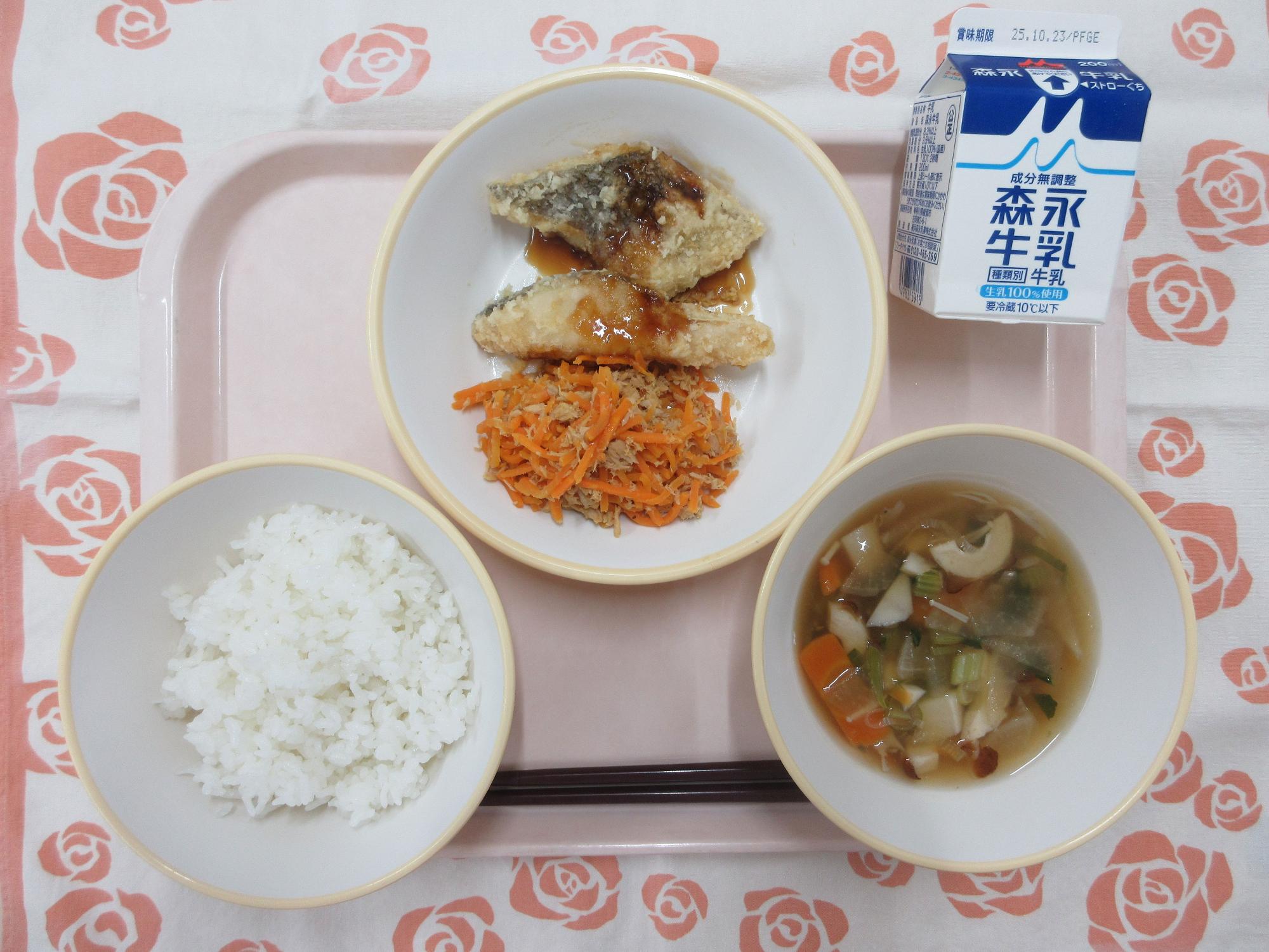 ピンクのトレーに給食が右上から反時計回りで牛乳、白身魚のかりん揚げ、にんじんしりしり、ごはん、のっぺい汁と並べられている写真