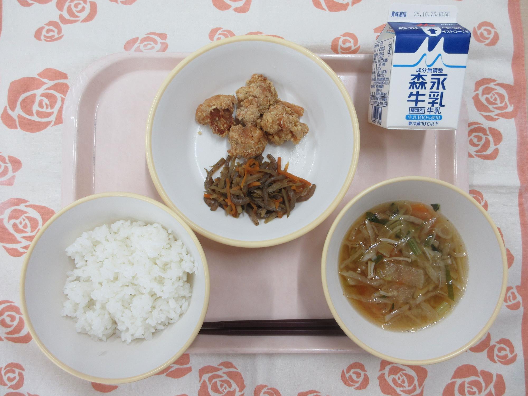 ピンクのトレーに給食が右上から反時計回りで牛乳、鶏肉のから揚げ、きんぴらごぼう、ごはん、切り干し大根のピリ辛スープと並べられている写真