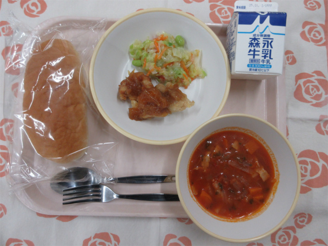 ピンクのトレーに給食が右上から反時計回りで牛乳、コーンドレッシングサラダ、鶏肉のバーベキューソース、ソフトフランスパン、トマトスープと並べられている写真