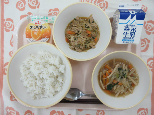 ピンクのトレーに給食が右上から反時計回りで牛乳、プルコギ丼の具、オレンジゼリー、プルコギ丼（麦入りごはん）、切り干し大根のピリ辛スープと並べられている写真