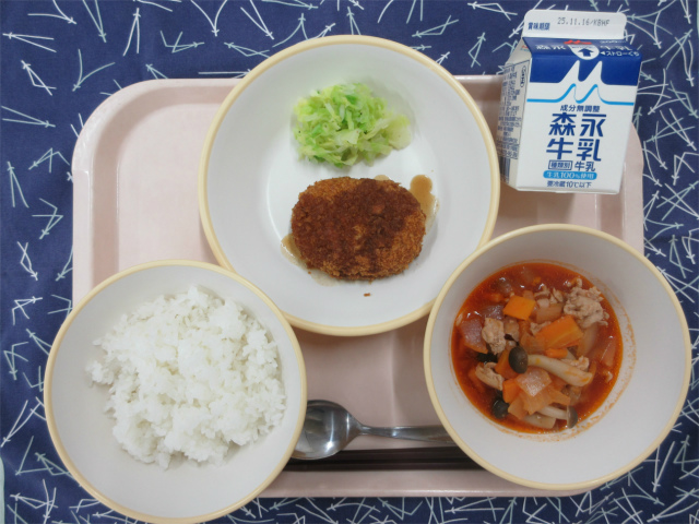 ピンクのトレーに給食が右上から反時計回りで牛乳、千切りキャベツ、コロッケ、ごはん、豚肉のトマト煮と並べられている写真