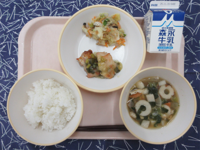 ピンクのトレーに給食が右上から反時計回りで牛乳、野菜のごま炒め、鶏肉のねぎ塩焼き、ごはん、のっぺい汁と並べられている写真
