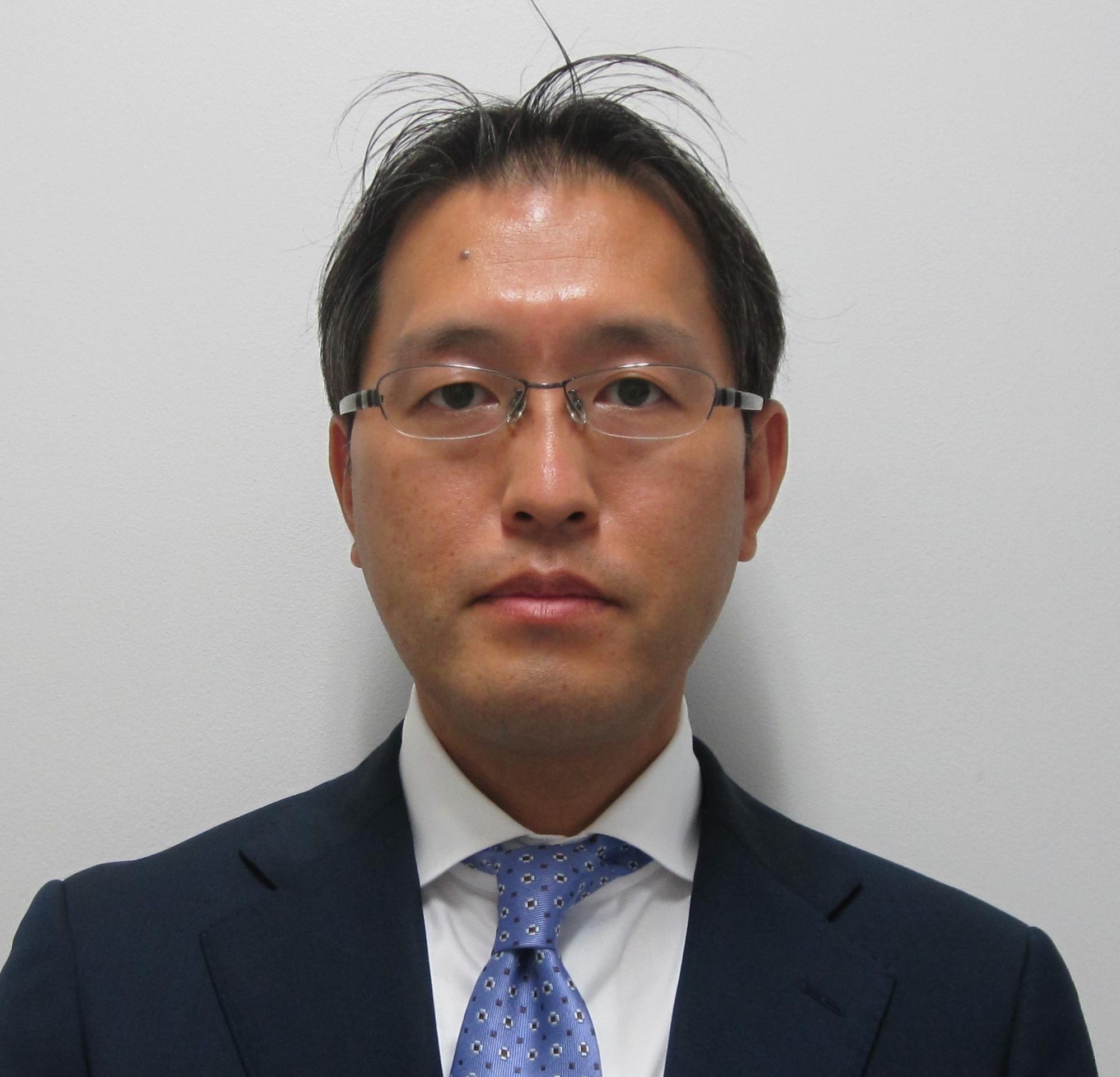 正面から写したスーツ姿の大江氏の上半身の写真