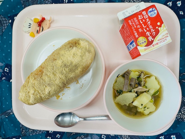 ピンクのトレーに牛乳、コック帽をかぶった布製マスコット、きなこあげパン、わふうポトフと並べられている写真