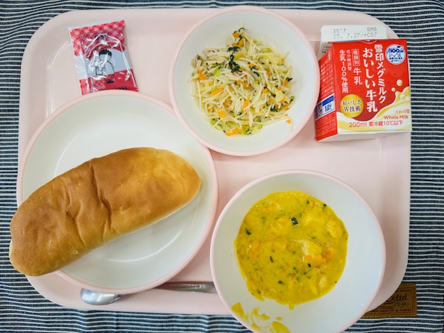 ピンクのトレーに牛乳、ビーフンソテー、チョコだいずクリーム、コッペパン、かぼちゃのクリームスープと並べられている写真