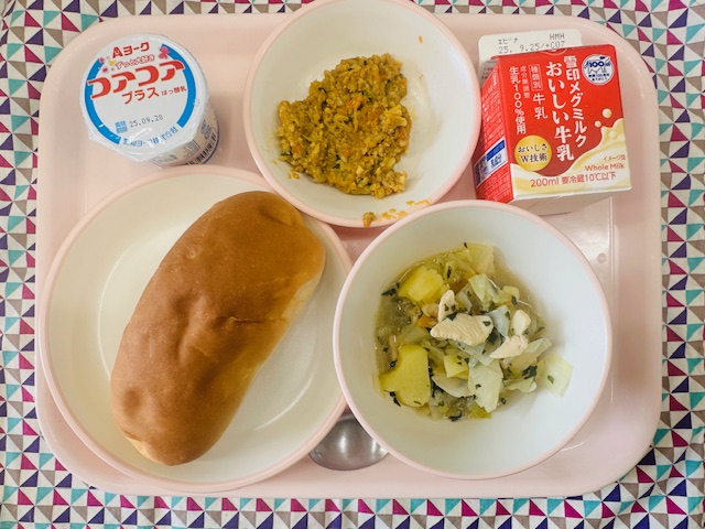 ピンクのトレーに牛乳、ドライカレー、ヨーグルト、ソフトフランスパン、やさいのスープにが並べられている写真