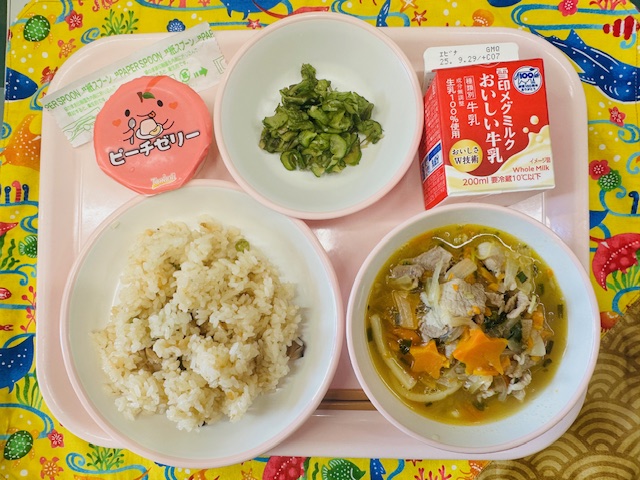 ピンクのトレーに牛乳、ぴりからきゅうり、ももゼリー、かしわずし、肉うどんと並べられている写真