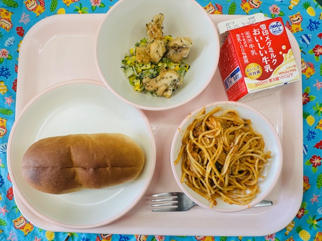 ピンクのトレーに牛乳、なすのミートソーススパゲティ、ソフトフランスパン、とりにくのハーブあげ、ミックスソテーと並べられている写真