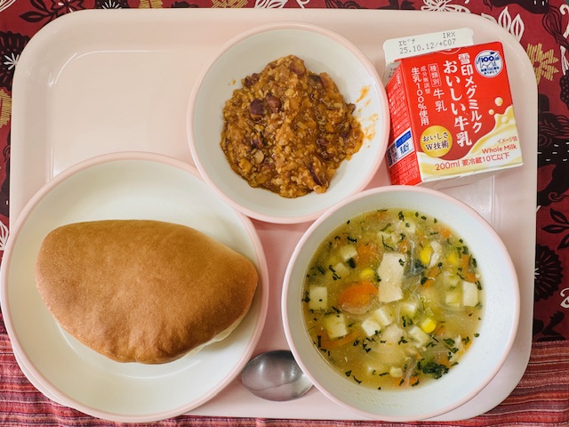 ピンクのトレーに牛乳、コーンちゅうかスープ、サンドパン、チリコンカンと並べられている写真