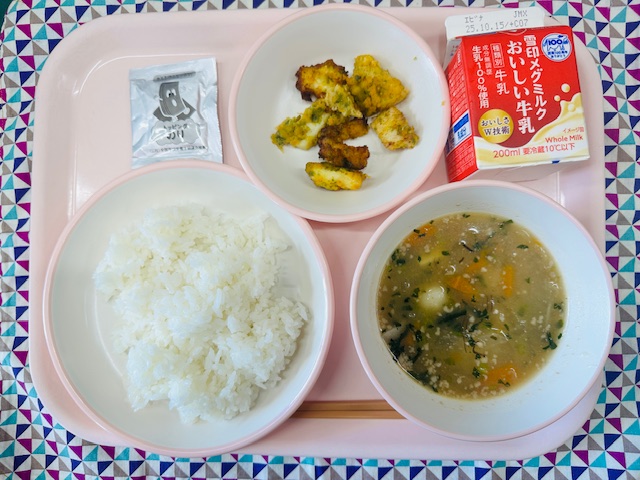 ピンクのトレーに牛乳、つきみじる、ごはん、のりふりかけ、いかのころもあげと並べられている写真