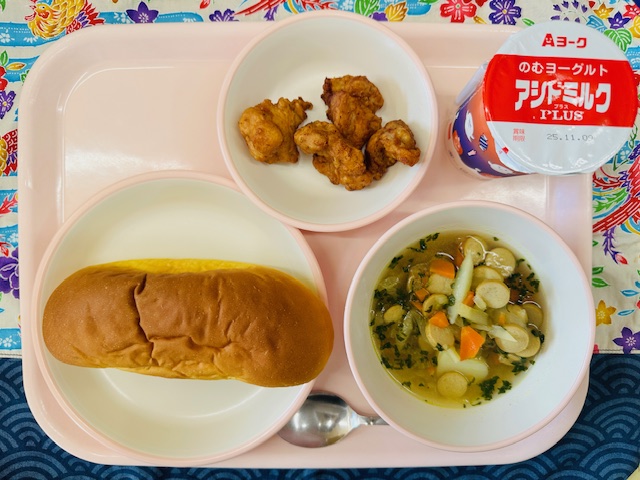 ピンクのトレーに発酵乳、だいこんのカレースープ、パンプキンパン、とりにくのフリッターと並べられている写真