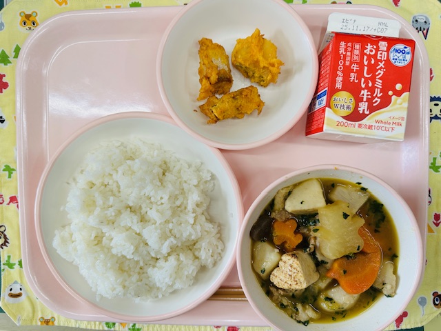 ピンクのトレーに牛乳、さといもと焼き豆腐のうま煮、たにやさんのごはん、さかなのもみじ揚げと並べられている写真