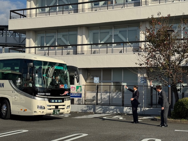 手をつなぐ育成会社会見学のバス見送り